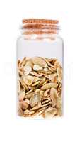 Pumpkin seeds in a glass bottle with cork stopper, isolated on w