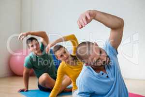 Yoga teacher with student exercising in club