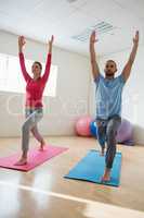 Yoga instructor with student practicing warrior 1 pose
