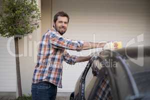 Man washing a car on a sunny day