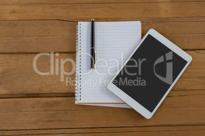 Blank notepad and digital tablet on wooden plank