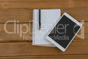 Blank notepad and digital tablet on wooden plank