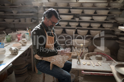 Male potter molding a clay