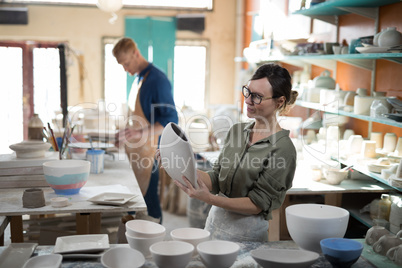 Female potter checking craft product