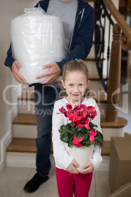 Father and daughter opening cardboard boxes in living room