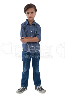 Boy standing with arms crossed against white background