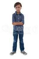 Boy standing with arms crossed against white background