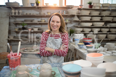 Portrait of female potter standing at worktop