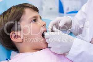 Boy receiving dental treatment by dentist