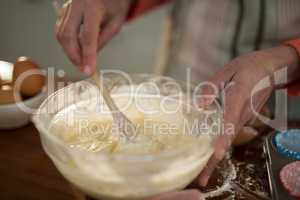 Woman mixing eggs and wheat flour in a bowl
