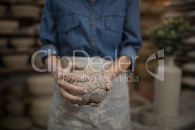 Mid section female potter holding molded clay