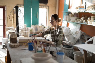 Female potter working at worktop