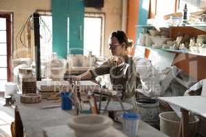 Female potter working at worktop