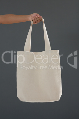 Cropped hand of female customer holding shoulder bag