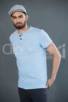 Handsome man posing with hands in pocket against grey background