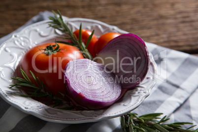 Fresh onions tomatoes and rosemary in bowl