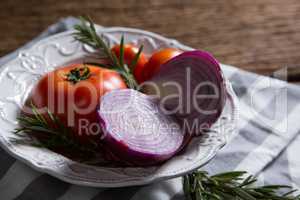 Fresh onions tomatoes and rosemary in bowl