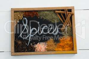 Word spices written on slate with various spices