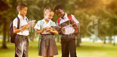 Composite image of students in uniforms using digital tablets