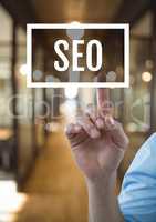 Hand interacting with SEO business text against blurred background