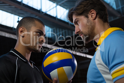 Aggressive volleyball players looking each other at court