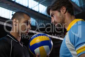 Aggressive volleyball players looking each other at court