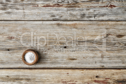 free space for text. Kitchen salt in a salt shaker on a wooden table,