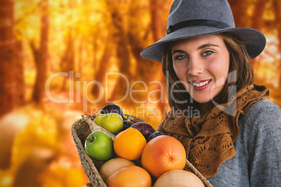 Composite image of portrait of woman carrying fruits and vegetables in basket