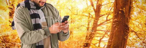 Composite image of smiling man using mobile phone