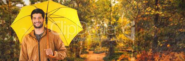 Composite image of portrait of smiling man holding yellow umbrella