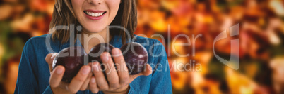 Composite image of portrait of woman holding plums