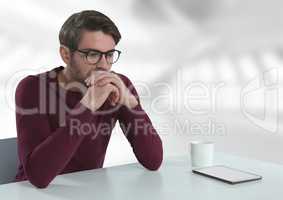 Businessman with tablet at desk with bright background