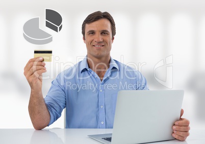 Businessman with laptop at desk with diagram pie chart and bank card