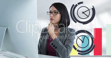 Businesswoman with computer at desk with clock diagrams