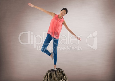 Woman balancing on rock with mystic background
