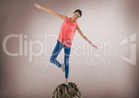 Woman balancing on rock with mystic background