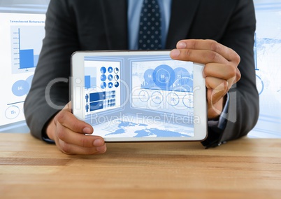 Businessman at desk with tablet and statistics information