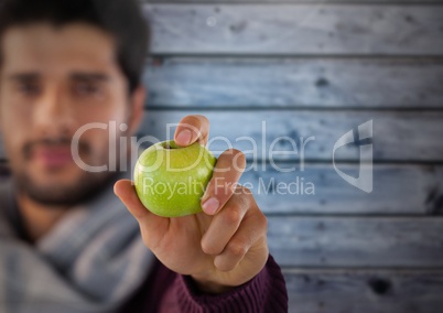 Man against wood with apple and scarf