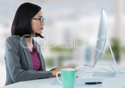 Businesswoman at desk with computer with bright background