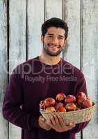 Man against wood with basket of apples
