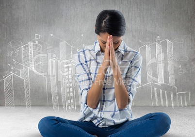 Woman praying meditating in front of city drawings