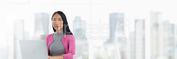 Businesswoman on laptop with bright city background