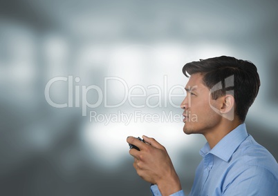 man playing with computer game controller with bright windows background