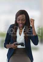 Businesswoman playing with computer game controller with bright blurred background