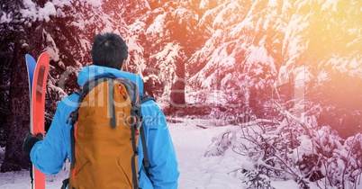 Man standing with skies in snow Forrest
