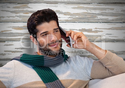 Man against wood with warm scarf and phone
