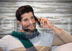 Man against wood with warm scarf and phone