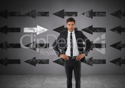 Businessman with arms on hips and arrows in opposite direction