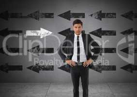 Businessman with arms on hips and arrows in opposite direction