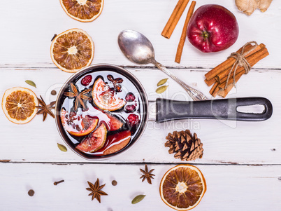 mulled wine with spices and fruits in an aluminum container